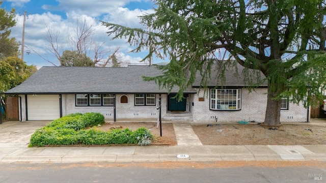 single story home featuring brick siding, driveway, an attached garage, and roof with shingles