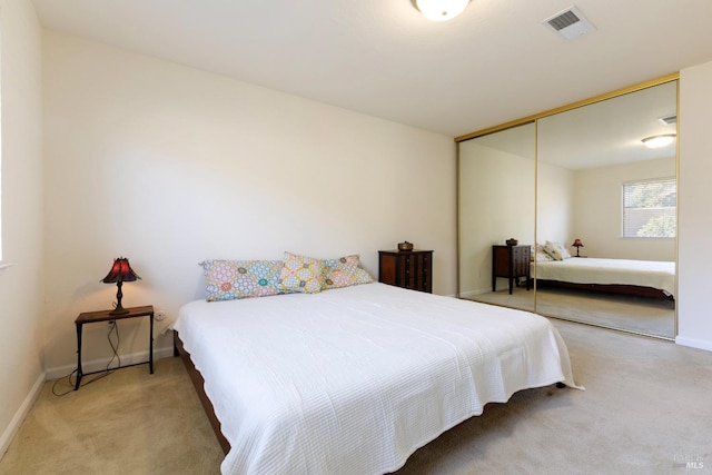 bedroom featuring a closet, carpet, visible vents, and baseboards