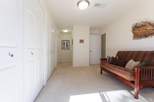 sitting room featuring light carpet, visible vents, and baseboards