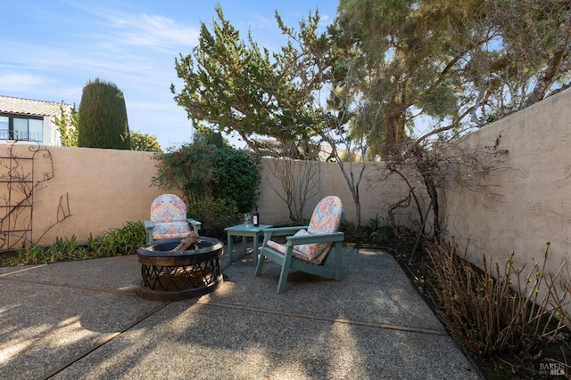 view of patio / terrace featuring an outdoor fire pit and a fenced backyard