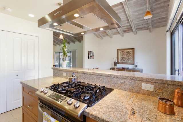 kitchen featuring exhaust hood, light stone counters, beamed ceiling, stainless steel range with gas stovetop, and light tile patterned flooring