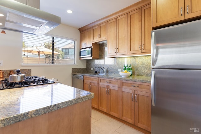 kitchen featuring light tile patterned floors, tasteful backsplash, appliances with stainless steel finishes, brown cabinetry, and extractor fan