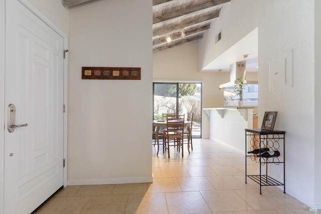 hallway with tile patterned flooring, baseboards, visible vents, and beamed ceiling