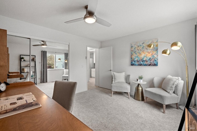 carpeted office with a ceiling fan