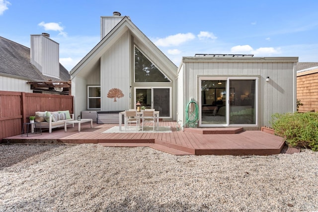 rear view of property featuring fence, an outdoor hangout area, and a wooden deck