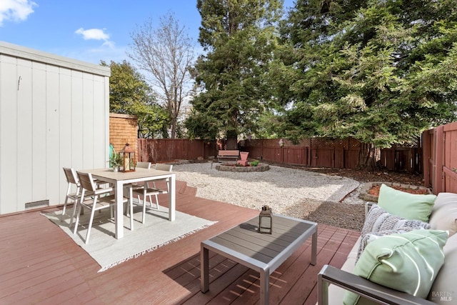 view of patio with a deck, outdoor dining space, a fenced backyard, and an outdoor living space