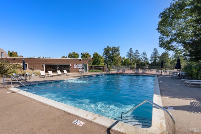 pool featuring fence and a patio