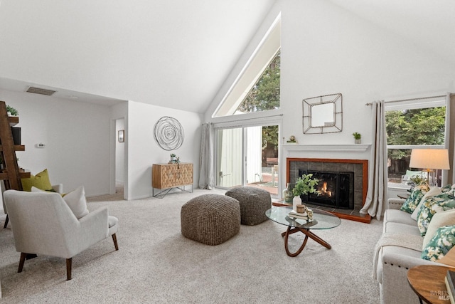 living area featuring high vaulted ceiling, a tiled fireplace, carpet flooring, and visible vents