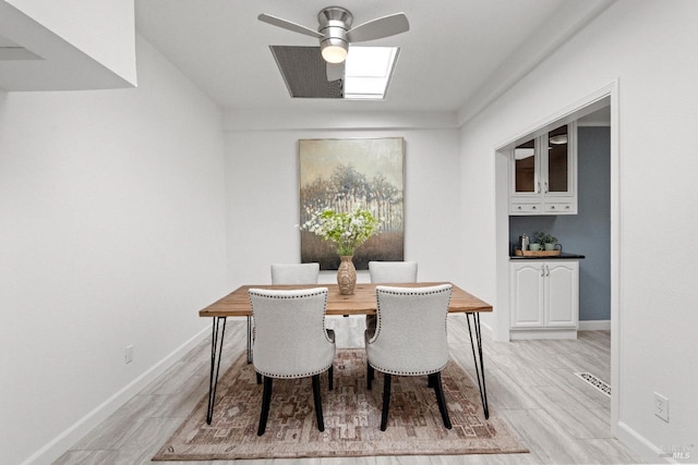 dining area with ceiling fan, light wood finished floors, visible vents, and baseboards