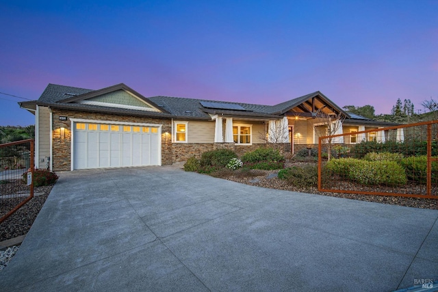 view of front facade featuring roof mounted solar panels, stone siding, and covered porch