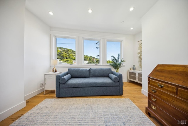 living area featuring baseboards, recessed lighting, and light wood-style floors