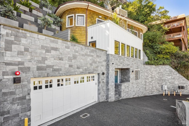 exterior space with a garage and stone siding