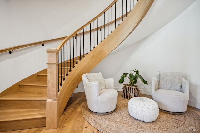 stairway with wood finished floors and baseboards