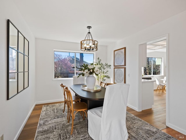 dining room featuring baseboards, wood finished floors, and a chandelier