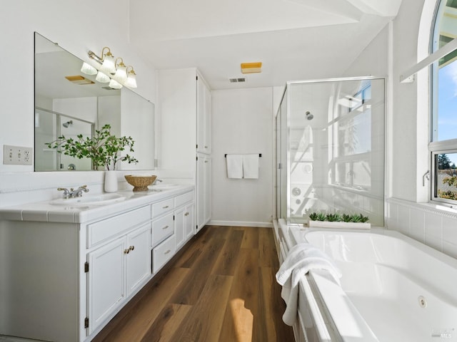 full bathroom with a whirlpool tub, wood finished floors, a sink, and a shower stall