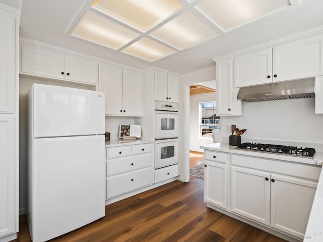 kitchen featuring white cabinets, light countertops, white appliances, dark wood-type flooring, and under cabinet range hood