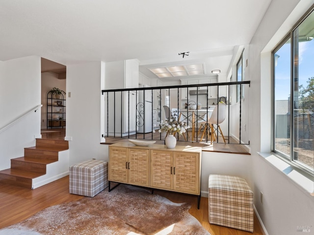 bar featuring baseboards, stairway, and wood finished floors