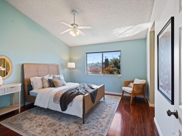 bedroom featuring baseboards, a ceiling fan, wood finished floors, vaulted ceiling, and a textured ceiling