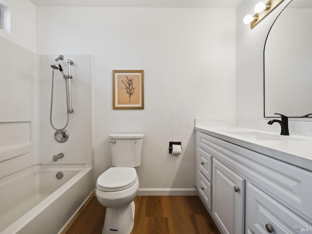 bathroom with toilet, vanity, shower / bathtub combination, wood finished floors, and baseboards