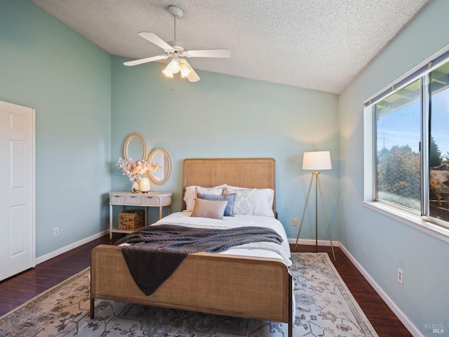 bedroom featuring a textured ceiling, baseboards, vaulted ceiling, and wood finished floors