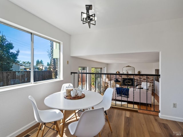 dining space featuring baseboards, a notable chandelier, visible vents, and wood finished floors