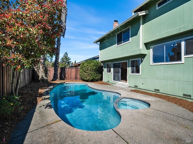 view of swimming pool featuring a fenced backyard, a pool with connected hot tub, entry steps, and a patio