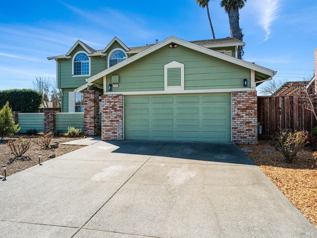 view of front facade featuring an attached garage, fence, brick siding, and concrete driveway