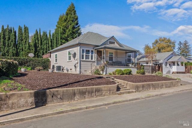 view of front facade featuring covered porch, concrete driveway, and central AC unit