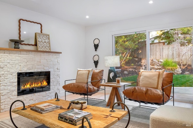 sitting room featuring a stone fireplace and recessed lighting