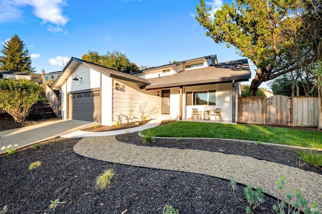 view of front of property with a garage, a front yard, fence, and brick siding