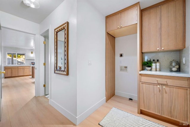 corridor with light wood-style flooring and baseboards