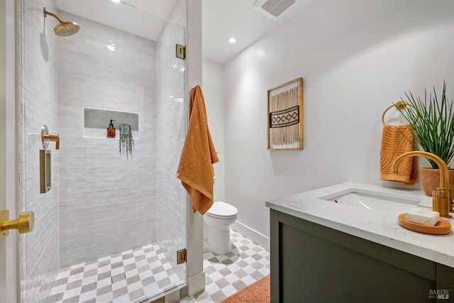 bathroom featuring toilet, vanity, a shower stall, and visible vents