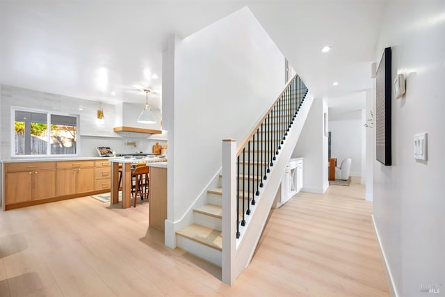 stairway with recessed lighting, baseboards, and wood finished floors