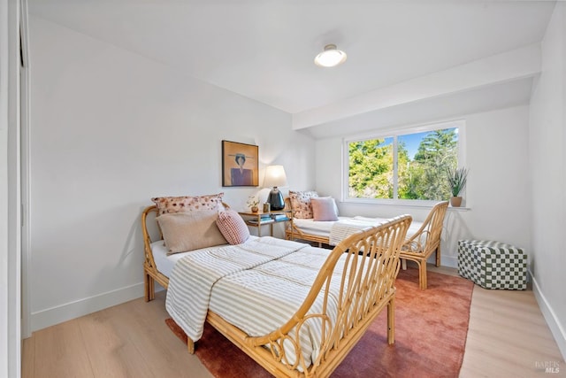 bedroom featuring light wood finished floors and baseboards