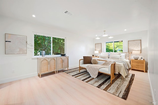 bedroom with baseboards, visible vents, wood finished floors, and recessed lighting