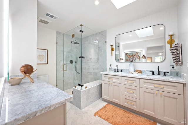 bathroom with a skylight, visible vents, a sink, and a stall shower