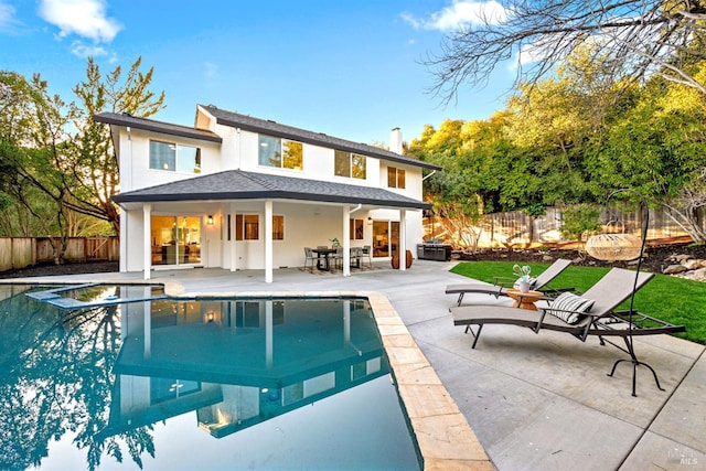 back of house featuring a patio area, a fenced backyard, a jacuzzi, and a fenced in pool