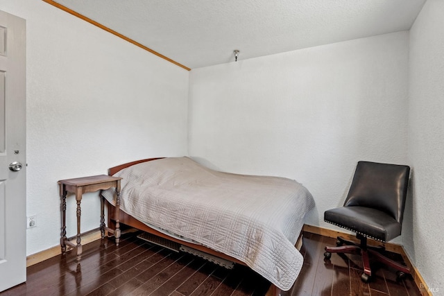 bedroom featuring baseboards and wood finished floors