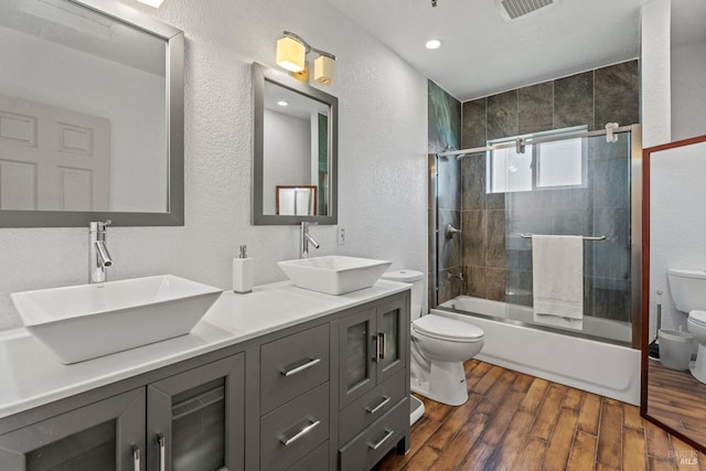 bathroom with visible vents, a sink, toilet, and wood finished floors