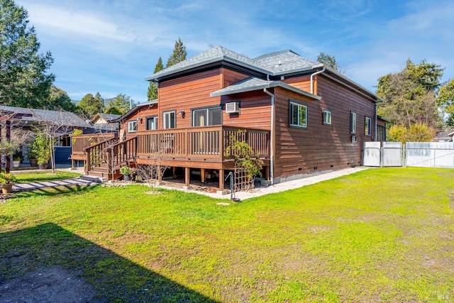 back of property with crawl space, fence, a deck, and a lawn