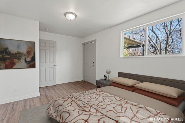 bedroom with wood finished floors and baseboards