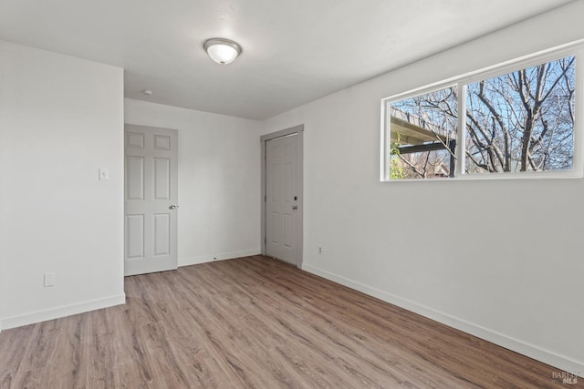 spare room with wood finished floors and baseboards