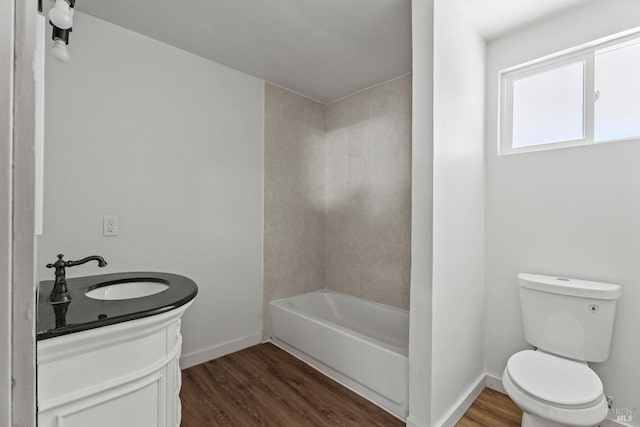 bathroom featuring baseboards, vanity, toilet, and wood finished floors