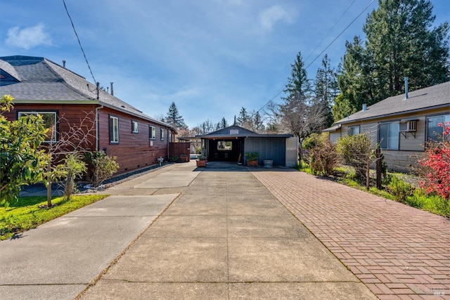 exterior space featuring an outbuilding, decorative driveway, and brick siding