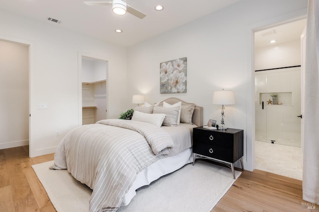 bedroom featuring light wood-type flooring, visible vents, recessed lighting, and a spacious closet