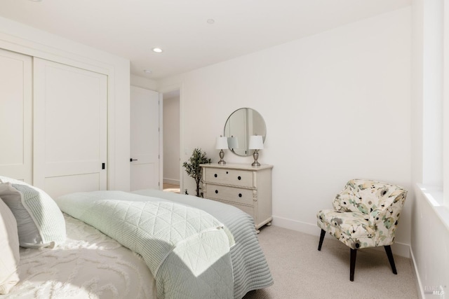 bedroom featuring light carpet, recessed lighting, baseboards, and a closet