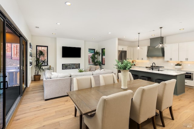 dining room with recessed lighting and light wood-style flooring