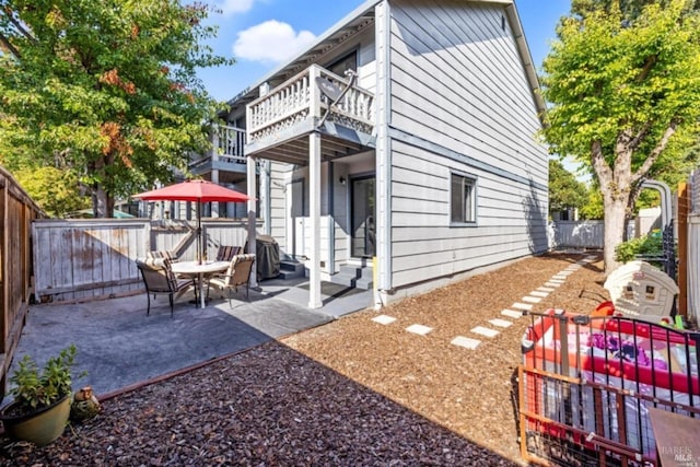 back of house with a patio area, a fenced backyard, and a balcony