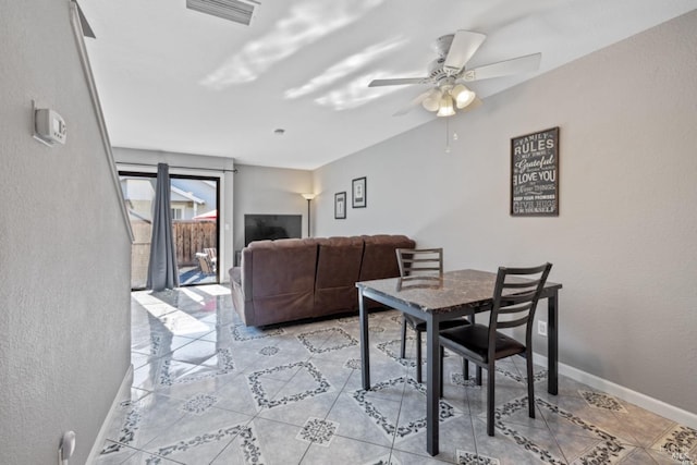 dining space with baseboards, visible vents, a ceiling fan, and a textured wall