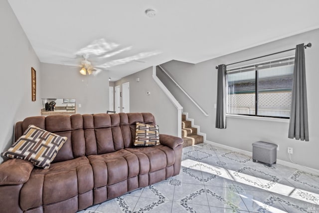 living room with light tile patterned flooring, ceiling fan, stairway, and baseboards